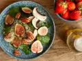 Sałatka z figami, orzechami i kiełkami – idealna na dietę kopenhaską. Obok miseczka truskawek i oliwa.