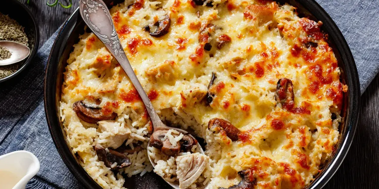Pyszna zapiekanka z ryżem, kurczakiem i grzybami, zapieczona pod złotym serem. Idealna na obiad.