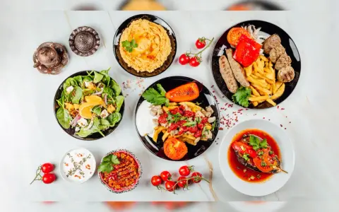 Kolorowe, zdrowe przekąski: sałatka ze szpinakiem, hummus, pieczone warzywa, frytki z mięsem i bakłażan w sosie.