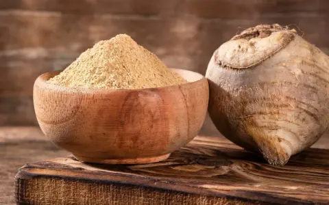 Korzeń maca i jego proszek w drewnianej misce. Poznaj korzeń maca właściwości i jego zastosowanie w kuchni i medycynie naturalnej.