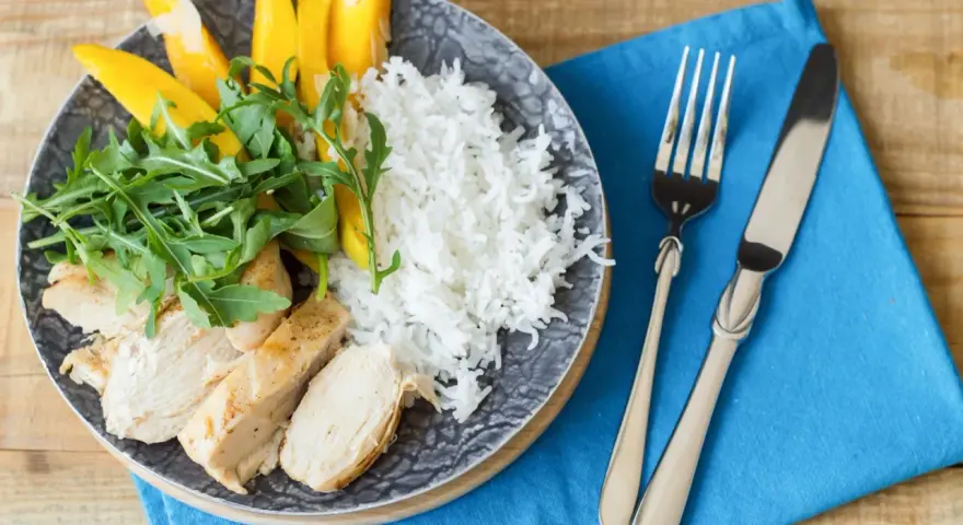 Idealny posiłek po treningu: grillowany kurczak, ryż, mango i rukola. Zdrowo i smacznie!