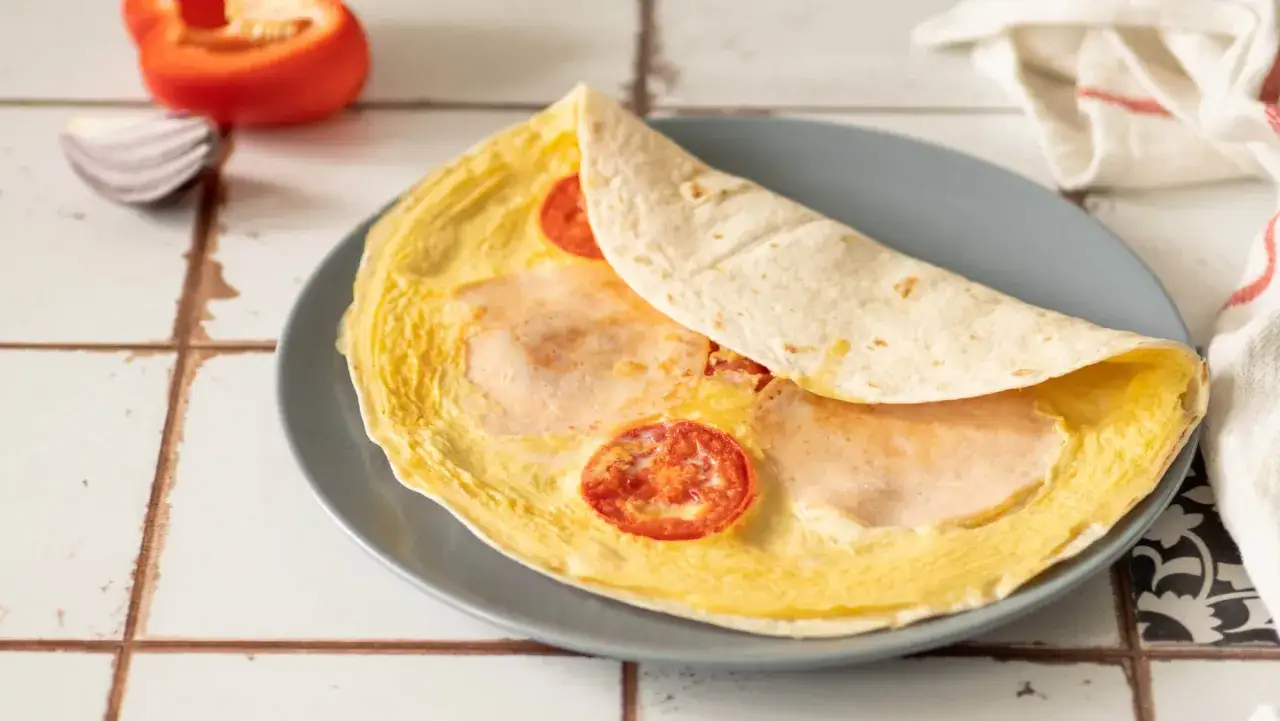 Pyszna tortilla na śniadanie z jajkiem, szynką i pomidorkami. Idealny początek dnia!